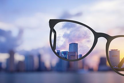 Glasses being held in front of a city