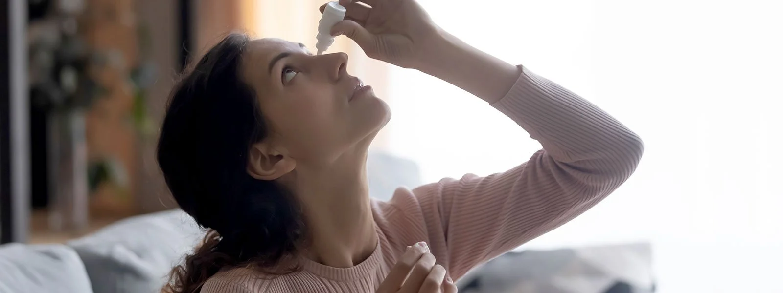 Woman using eye drops